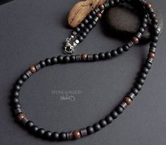 Necklace with matte black onyx beads, beautifully grained Mundambi wood beads and dark silver hematite discs. The bead diameter is 6 mm. Strung on a sturdy coated stainless steel wire with a stainless steel carabiner clasp Handcrafted Men’s Necklaces, Mens Wood Bead Necklace, Men's Black Beaded Necklace, Onyx Necklace Men, Luxury Onyx Beaded Necklace, Onyx Bead, Men's Necklace