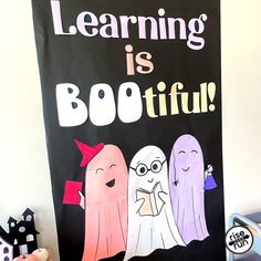 a sign that says learning is bootiful with three ghostes in front of it