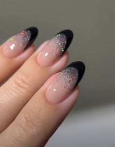 a woman's hand with black and white manicures on her nails, with glitter