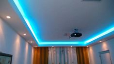 a room with white walls and blue lights on the ceiling is lit up by recessed lighting