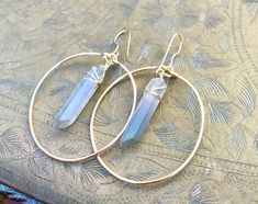 ⭐️Healing quartz Crystal property has been know for centuries to restore balance in the body, rid away negativity, and improve intuition. Why not wear them on your ears in these beautiful boho chic hoops! Not two crystals will look exactly the same but they are picked out where shape and size are as close as possible. Crystals are soured in their natural form and are not perfect, they may have slight cracks and blemishes and not uniformed. OPTIONS: White Angel Aura Pink Angel Aura Blue Angel Aur Handmade Bohemian Crystal Hoop Earrings, Wire Wrapped Hoop Earrings For Festivals, Bohemian Wire Wrapped Hoop Crystal Earrings, Festival Wire Wrapped Hoop Earrings, Aura Blue, Aura Pink, Raw Stone Earring, Boho Hoop Earrings, Pink Angel