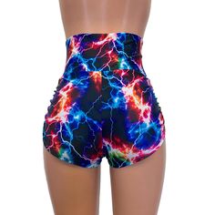 High-waisted booty shorts made in sparkle cosmic thunder UV Glow print stretchy performance spandex with ruching on the sides and lace-up detail in front. Made to flatter your figure and move with you. These booty shorts shine in different colors in the light - for a true holographic effect. The standard inseam is 2.5" - but can be customized. High Waist Shorts For Cheerleading In Summer, Stretch Rave Shorts, Fitted Rave Bottoms With Built-in Shorts, Trendy Stretch High-waisted Swim Shorts, Trendy High Waist Swimwear With Built-in Shorts, Trendy Stretch Bottoms For Cheerleading, Fitted Rave Shorts, Trendy High-waist Swimwear With Built-in Shorts, Trendy Fitted High Waist Athletic Shorts