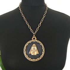 "Amazing glass and gold gilt metal medallion necklace. Signed 'Art' (Arthur Pepper).  Circular glass with gold plated metal decorative star surround, central metal pharaoh attached with a drilled rivet and signed on the back, gold-plated engraved chain and foldover clip fastening. Genuine original item - collectable and quite rare. 7\" diameter pendant 18\" chain Condition - age wear to gold plating, which has faded particularly on the chain and clasp, but this necklace is still in great condition for its age. The glass was thick with dust when I received it and I've given it a new lease of life." Gold Necklace With Coin Pendant For Festival, Gold-tone Metal Pendant Medallion Necklace, Antique Gold Medallion Necklace With Antique Finish, Festival Coin Pendant Medallion Necklace, Festival Medallion Necklace With Coin Pendant, Bronze Metal Medallion Necklace, Antique Finish Medallion Necklace, Gold Medallion Necklace With Antique Finish, Gold Necklace With Round Antique Pendant