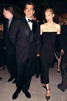 a man in a tuxedo standing next to a woman wearing a black dress