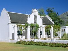 a large white house with some plants growing on it