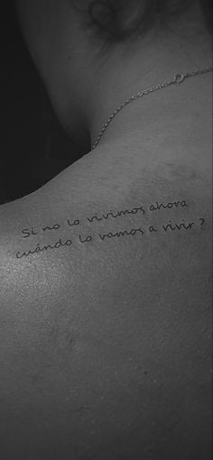 the back of a woman's shoulder with an inscription written in cursive writing