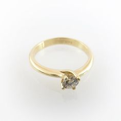 a yellow gold ring with a single diamond on it's center and two smaller diamonds in the middle