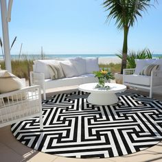 a black and white area rug on the ground with chairs, couches and palm trees in the background