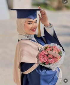 a woman wearing a graduation cap and gown holding a bouquet of roses in her hand