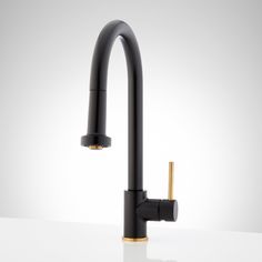 a black kitchen faucet with gold handles