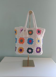 a crocheted bag sitting on top of a white table next to a blue wall