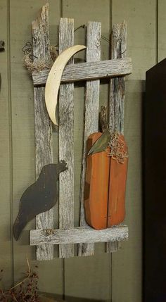 an old wooden shelf with two pumpkins and a bird on it, hanging from the wall