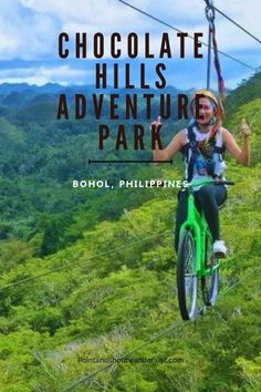 a woman riding a bike on top of a lush green hillside with text overlay reading chocolate hills adventure park bohol, philippines