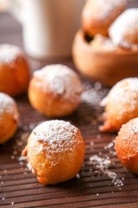 powdered sugar covered pastries sit on a cooling rack