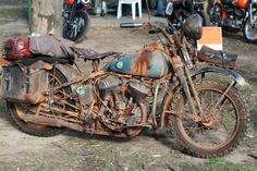 an old rusted motorcycle sitting in the dirt