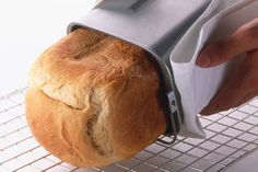 a loaf of bread is being held by a person with an oven mitt on it