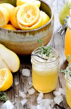 two jars filled with lemonade next to sliced oranges