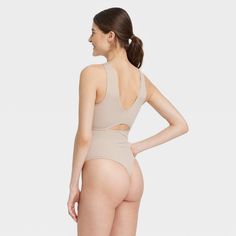 Add fashion-forward style to your intimates collection with the Cut Out Bodysuit from Colsie™. This beige bodysuit features a sleeveless design with cut-out detail at front and back for a stylish look. The boat neckline at front and V neckline at the back elevates the look. Designed with a soft and stretchy fabric, this cut-out bodysuit helps keep you comfortable and it's perfect for layering. Colsie™: All You, Inside and Out. Seamless High Cut Shapewear For Summer, High Cut Lined Body Shapewear For Summer, Fitted Beige Seamless Bodysuit, Sleeveless Beige Bodysuit With Built-in Bra, Summer High-cut Shapewear, Solid Color Backless Bodysuit For Loungewear, Chic Beige Lined Bodysuit, Stretch Cutout Backless Bodysuit, Chic Beige Stretch Swimwear