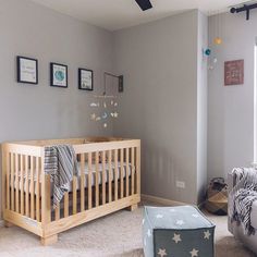 a baby's room with a crib, rocking chair and pictures on the wall