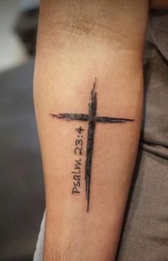 a cross tattoo on the arm