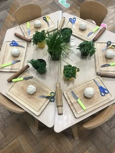 a table topped with cutting boards covered in plants and knickk knacks