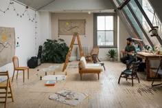 a person sitting in a room with lots of clutter on the floor and furniture