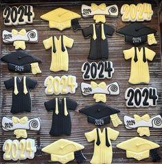 graduation cookies decorated in the shape of gowns and mortars are displayed on a table