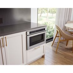 a kitchen with white cabinets and black counter tops is shown in front of a window