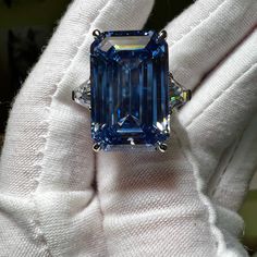 Carbon created 28CT emerald cut Swiss blue topaz statement ring.  This carbon created aquamarine has a 20% higher refractive index and 16.6% more gloss than earth mined diamonds.  🔥Looking for spectacular fire?  925 sterling silver/ 18K white gold plating 28CT carbon based aquamarine 2 x 1CT trillion cut carbon based accents stones Size  7 for immediate shipping Luxury Blue Cubic Zirconia Topaz Ring, Luxury Blue Topaz Diamond Cut Jewelry, Luxury Exquisite Topaz Wedding Ring, Luxury Brilliant Cut Topaz Ring In Fine Jewelry Style, Luxury Dazzling Blue Topaz Rings, Luxury Topaz Birthstone Gemstones, Blue Radiant-cut Emerald Ring In Fine Jewelry Style, Blue Radiant Cut Emerald Ring In Fine Jewelry, Blue Radiant-cut Emerald Ring Fine Jewelry