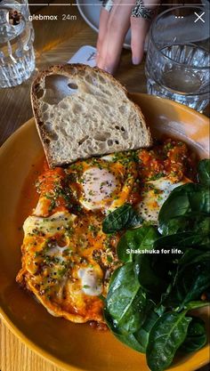 an omelet with spinach and bread on a yellow plate