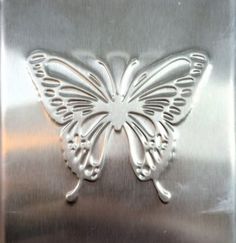 a stainless steel flask with a butterfly cut out on it's back side