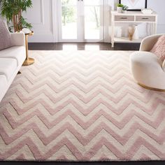 a living room with a white couch and pink rug