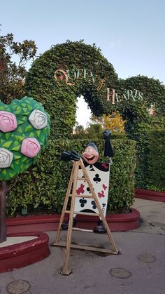 a statue of a man in front of a garden with roses on it's head