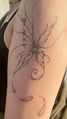 a woman's arm with a butterfly tattoo on the back of her shoulder,