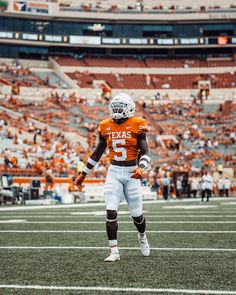 a football player in an orange jersey and white uniform is on the field during a game