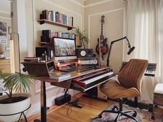 a living room filled with furniture and a musical keyboard on top of a wooden table