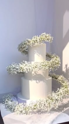 a three tiered cake with white flowers on top