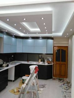 a kitchen that is being remodeled with lights on the ceiling and paint rollers in front of it