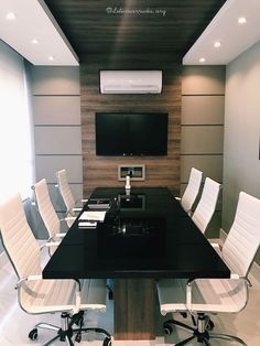 an empty conference room with black table and white chairs