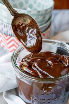 a spoon full of chocolate pudding in a jar