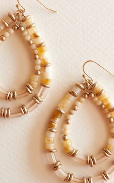 These earrings feature a teardrop design adorned with a harmonious blend of gold-toned accents and delicate shell beads, creating a captivating play of light and texture. Perfect for those who appreciate both sophistication and a touch of nature-inspired charm, these earrings effortlessly elevate any outfit. Whether you're dressing up for a special occasion or adding flair to your daily look, the Cat Beaded Teardrop Dangle Earrings are a perfect choice for expressing your unique style. Elegant Teardrop Beaded Earrings For Beach, Gold Beaded Teardrop Dangle Earrings, Gold Teardrop Beaded Earrings With Tiny Beads, Gold Bohemian Beaded Earrings With Pearl Drop, Gold Teardrop Jewelry With Colorful Beads, Gold Teardrop Earrings With Tiny Beads, Unique Teardrop Beaded Earrings, Beige Teardrop Bohemian Jewelry, Gold Teardrop Beaded Hoop Earrings