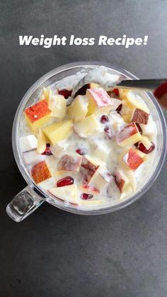 a bowl filled with fruit and yogurt next to a spoon on top of a table