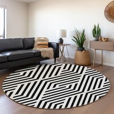 a living room with black and white rugs on the floor, leather couches and potted plants