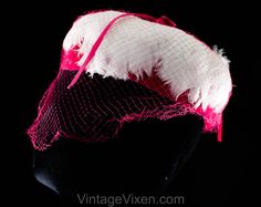 "This dome-shaped 1960s spring hat is a soft layer of thick white feathers over a base of vivid pink velvet, so charming and coy with a \"cage\" of veiling. Measurements 20 3/8 Inches Circumference at inside base of crown, approx Height 3 Inches Era 1960s Label Union label to inside back Materials White feathers, shocking pink synthetic velvet and matching diamond pattern net, matching pink stiff buckram frame Closure None needed Condition Good Condition Detail Barely worn, the netting has 6-8 s Retro Pink Brimmed Hat, Vintage Pink Fitted Fascinator, Vintage Pink Mini Hat With Curved Brim, Vintage Pink Costume Hats And Headpieces For Party, Vintage Pink Party Hat And Headpiece, Pink Vintage Costume Hat For Parties, Pink Retro Party Hats, Vintage Pink Fascinator For Kentucky Derby, Pink Vintage Fascinator For Kentucky Derby