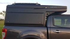 the back end of a pick up truck parked in a field