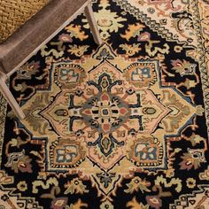 an old wooden chair sitting on top of a rug next to a black and yellow area rug