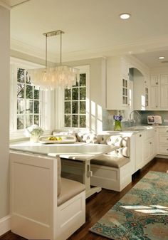 a large kitchen with white cabinets and an island in the middle, along with lots of windows