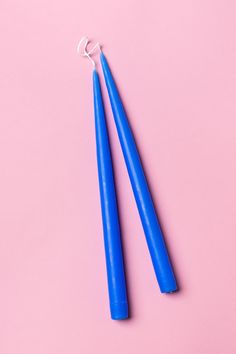 two blue toothbrushes on a pink background