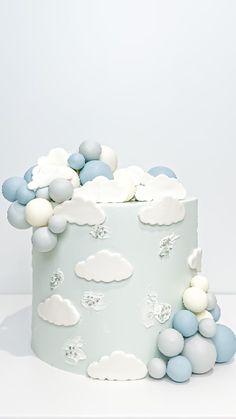 a white cake with blue and white clouds on it's side, sitting on a table