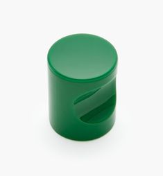 a green plastic container with an open lid on a white surface, showing the top part of it